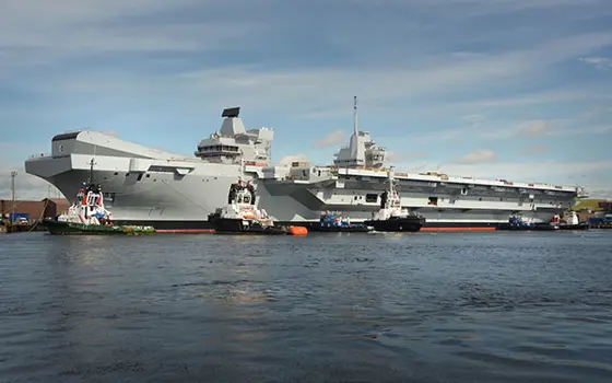 The HMS Queen Elizabeth parked at a dock. 