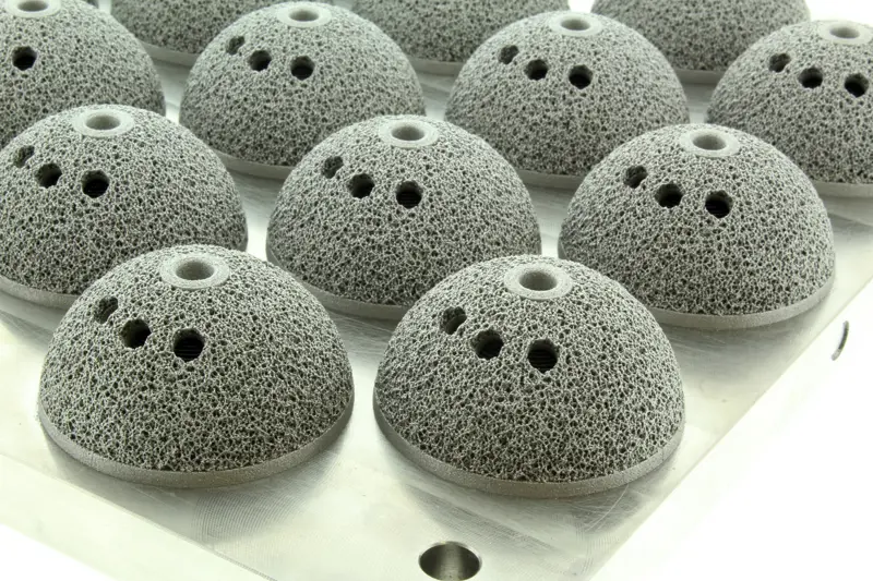 Semi spheres made of load-bearing lattice structures. The semi spheres have four holes at the top of the structure.
