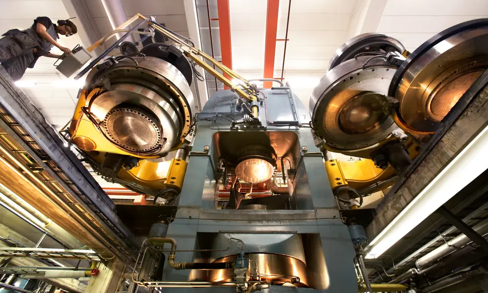 A large diamond press machine inside, with a person operating it towards the left. 
