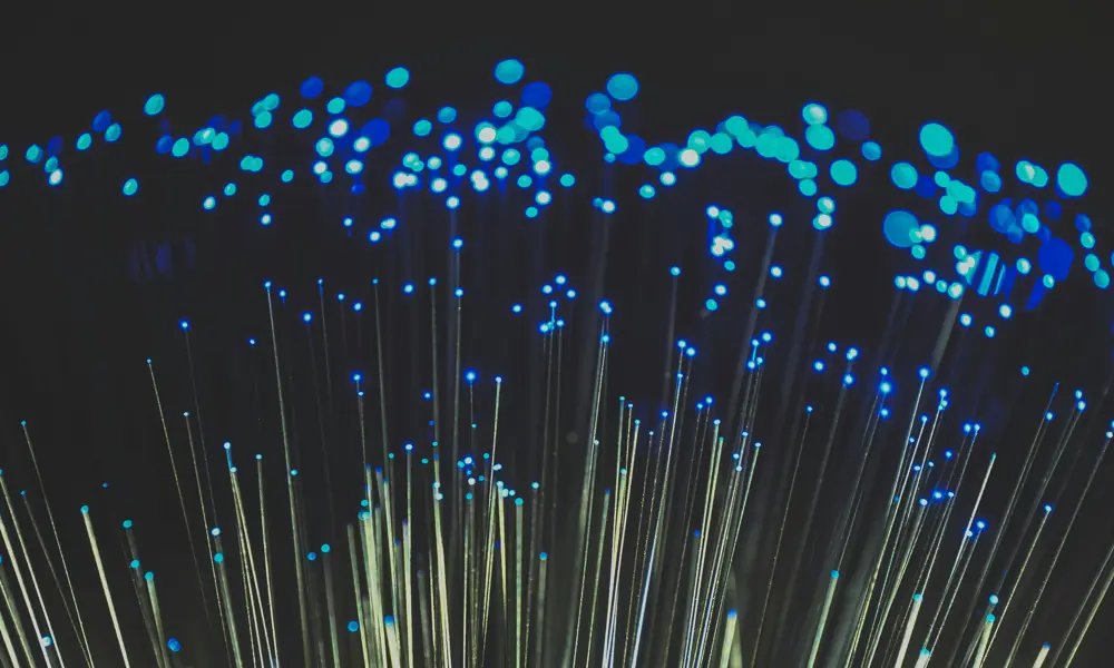 Fiber optic light cables with red hue on black background.
