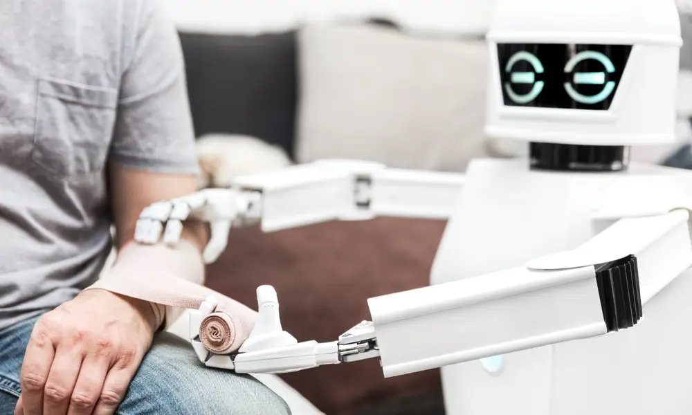 A small white robot bandaging up a person's forearm.