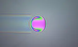 Coloured optical interference fringes around a ball.