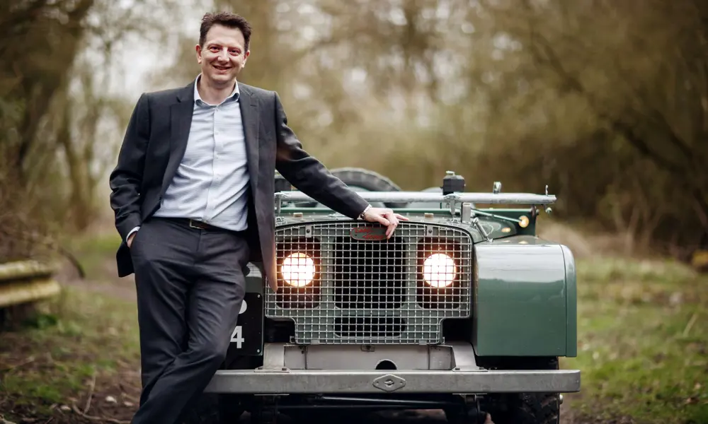 Nick Rogers smiling, standing in front of a Land Rover.