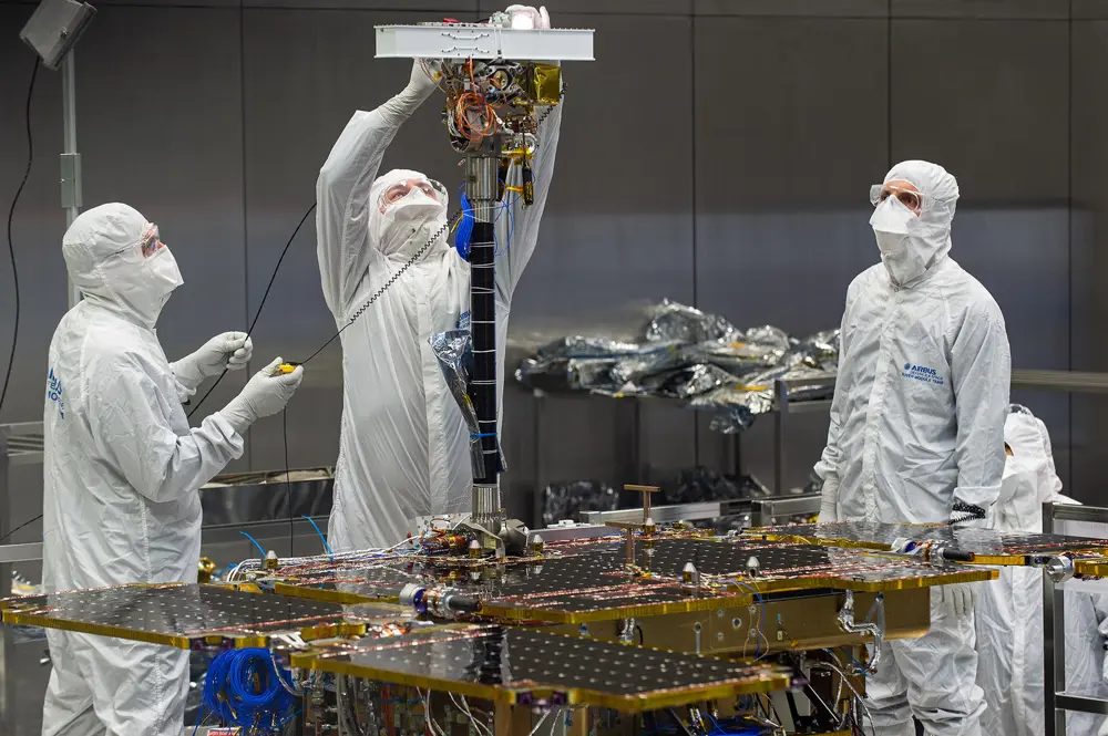 Three staff fit the PanCam to the ExoMars rover in Stevenage. 