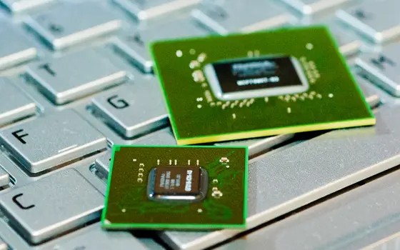 Two GPUs resting on top of a keyboard. 