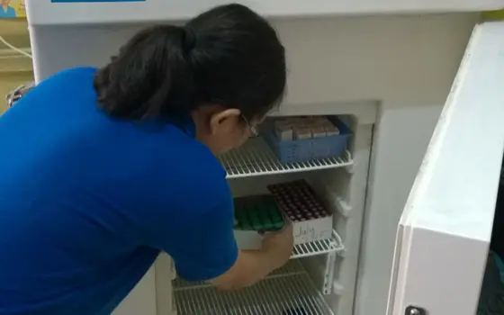 Someone putting medicines into a freezer.