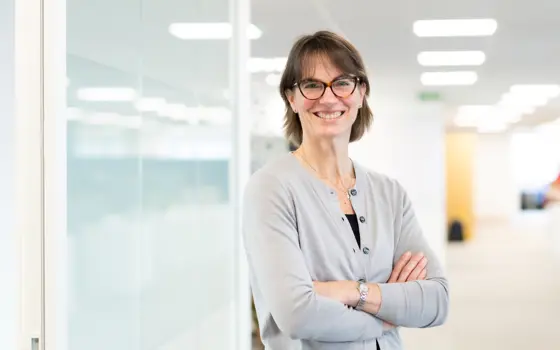 A woman in glasses looking relaxed and smiling in an office