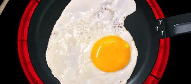 A fried egg in a pan on an induction hob.