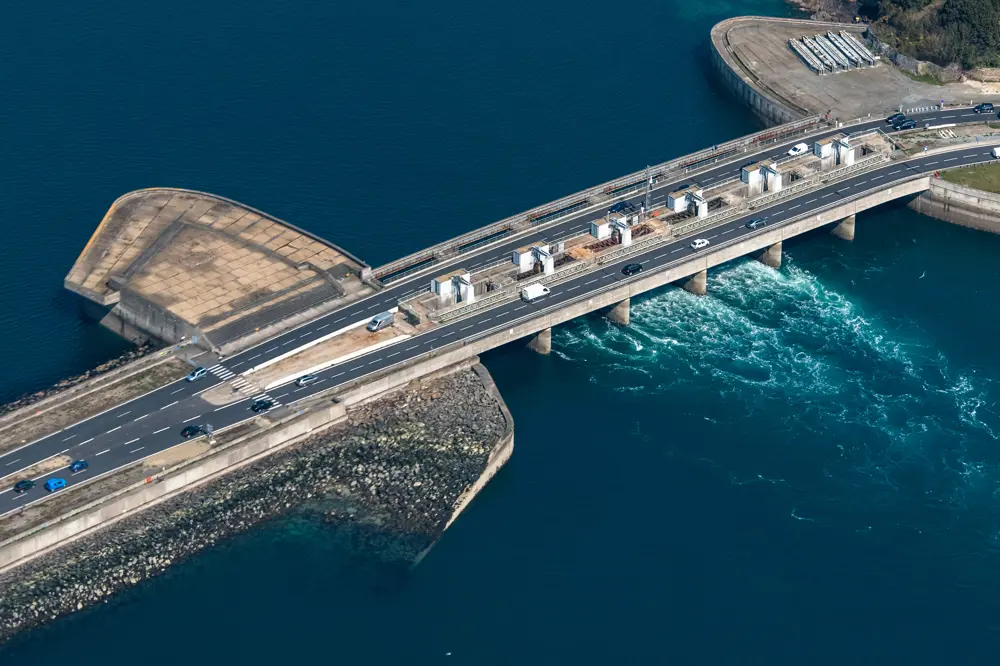 A photograph of a main road crossing a dam, which is connected to the tidal power station on the Rance River estuary.