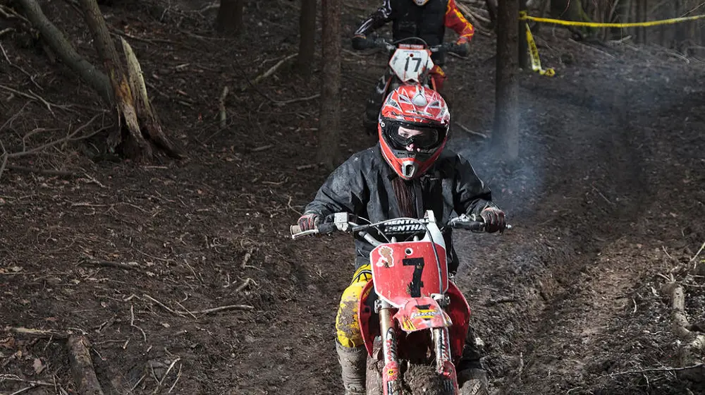 A young person riding a motorbike off-road. 